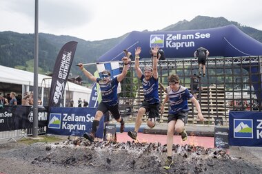 3 participants jump over a fire as the last obstacle in the Spartan Race | © Zell am See-Kaprun Tourismus