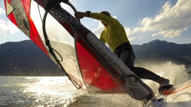 Gliding across the lake on a surfboard | © Zell am See-Kaprun Tourismus